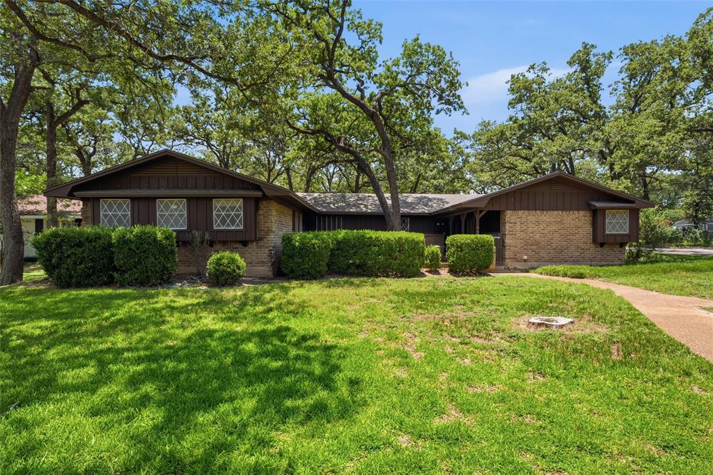Ranch-style residence featuring a brick and dark wood exterior Ranch-style residence featuring a brick and dark wood exterior