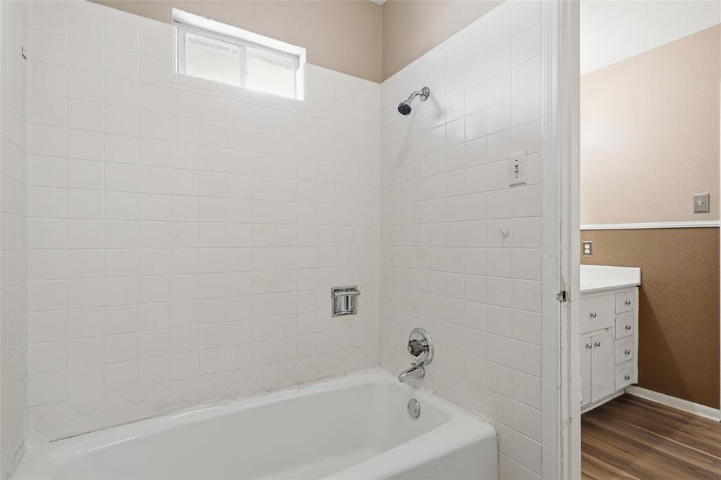 Bathtub with white tile surround and chrome fixtures
