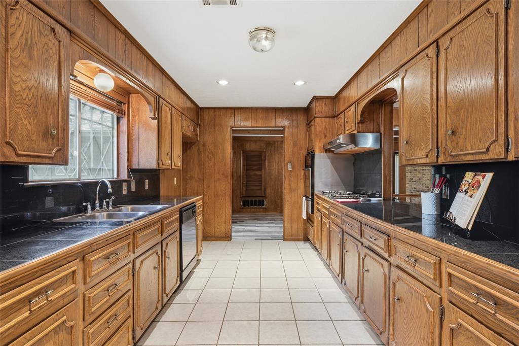 Galley kitchen featuring extensive wood paneling and cabinetry
