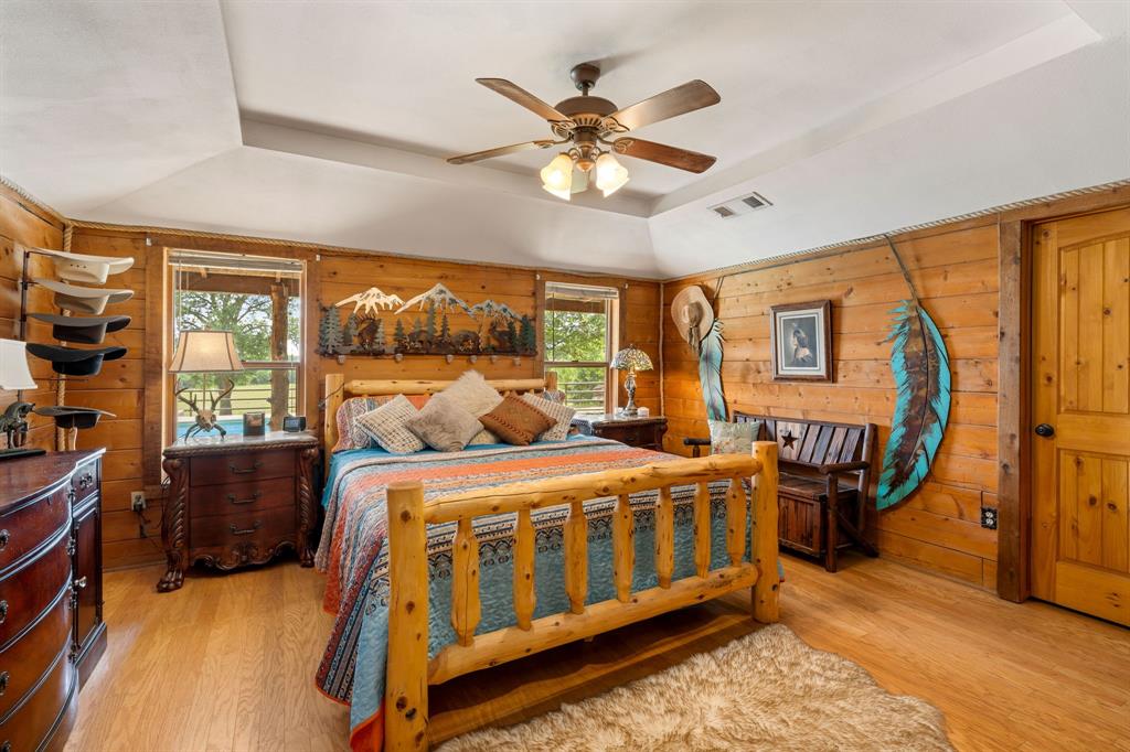 Bedroom featuring wood-finish flooring and extensive wood paneling