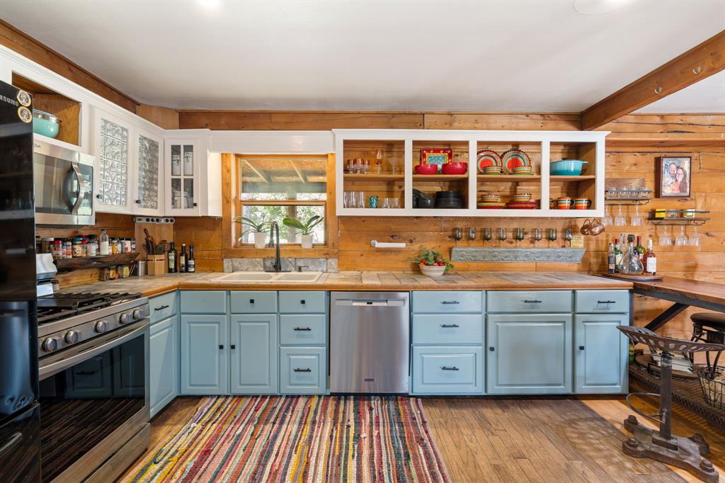 Kitchen featuring wood-finish flooring, a stainless steel range, and a stainless steel dishwasher