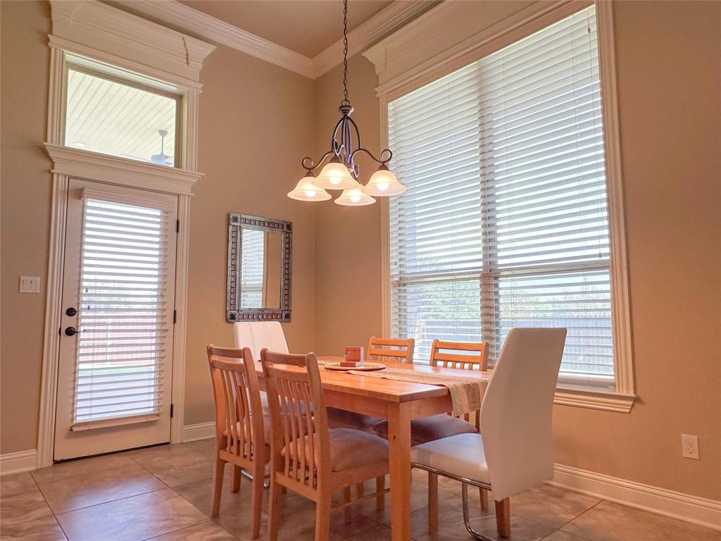 Dining area featuring a high ceiling, crown molding, and tiled flooring