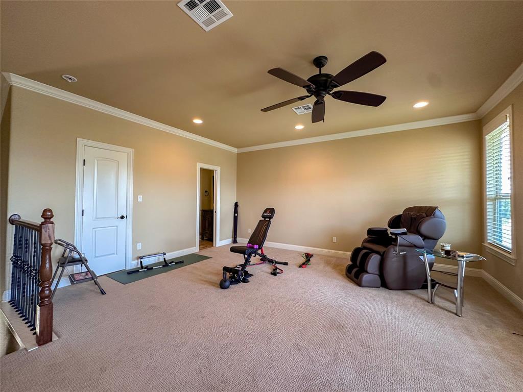 Carpeted room featuring a ceiling fan, recessed lighting, crown molding, and window blinds