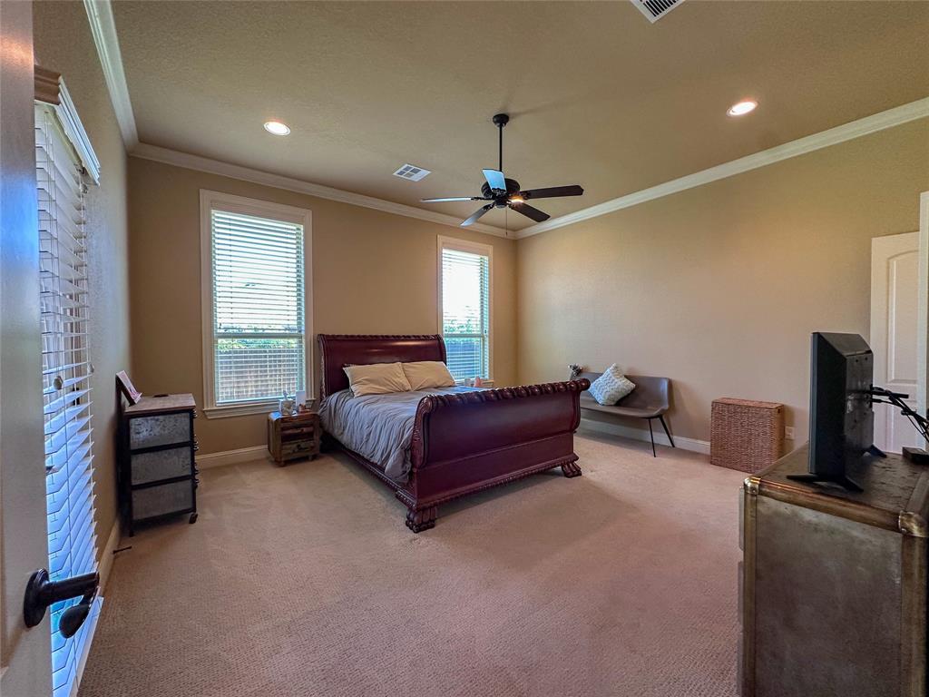 Carpeted room featuring two windows with horizontal blinds, recessed lighting, and a ceiling fan with a light fixture