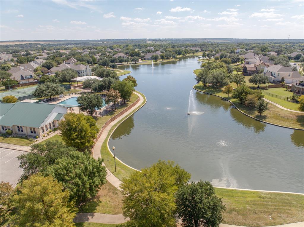 Expansive lake with multiple fountains, surrounded by mature trees and residential properties