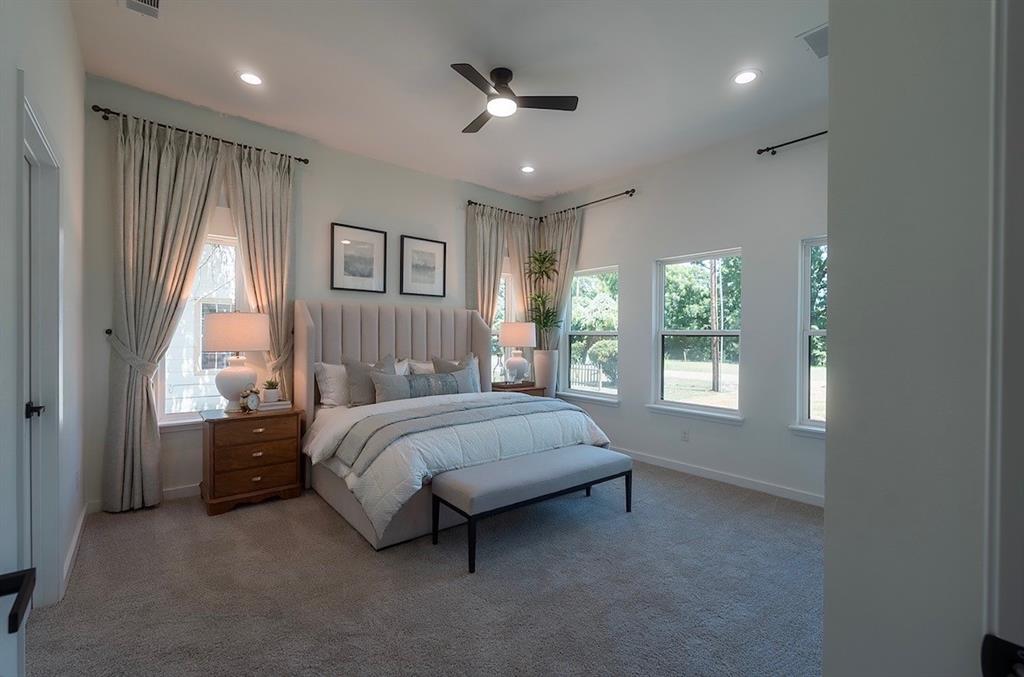 Carpeted bedroom featuring an upholstered headboard, a ceiling fan with integrated lighting, recessed lighting, and multiple windows with curtain rods