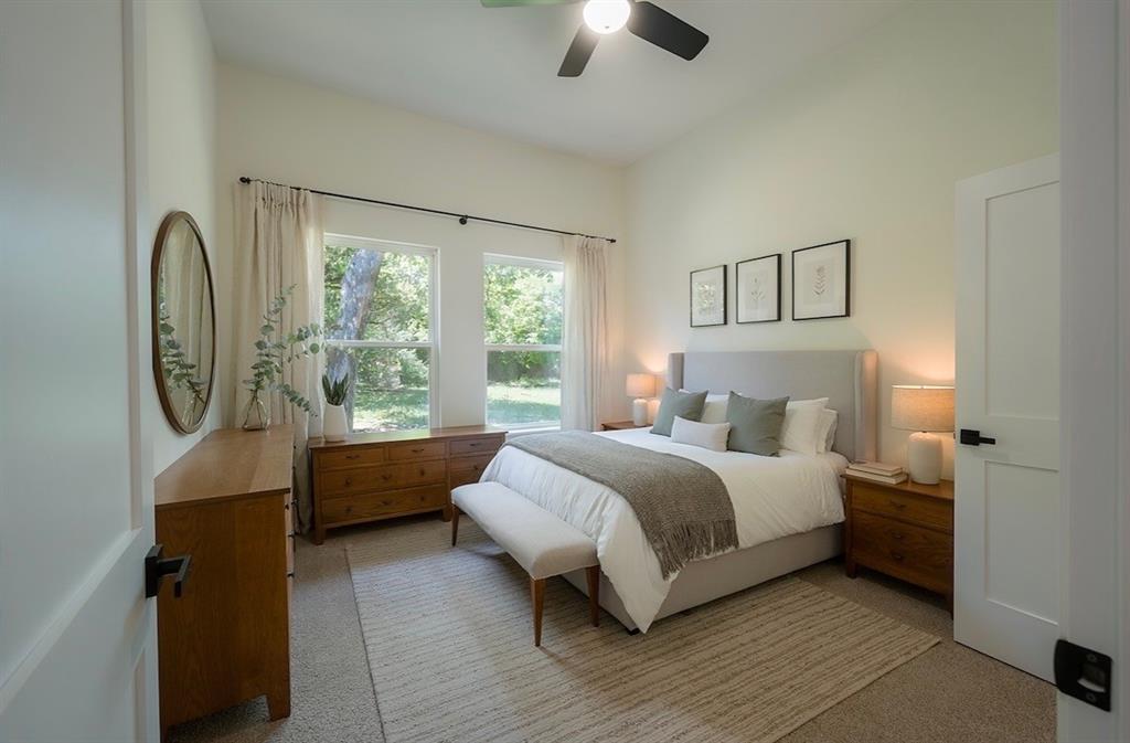 Spacious bedroom featuring light-colored walls and carpet flooring