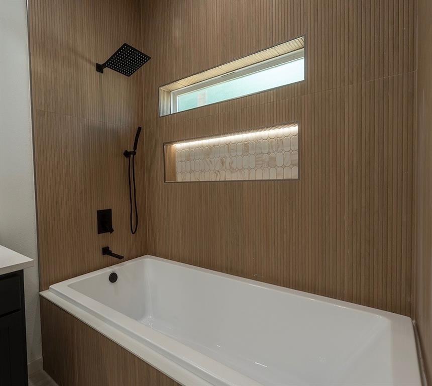 Built-in bathtub with matte black fixtures and a rainfall showerhead