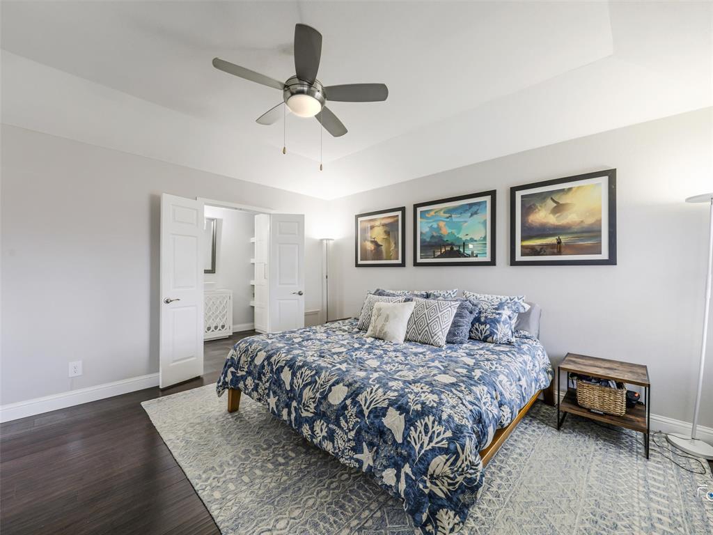 This view of the primary bedroom gives you a peak of the primary bathroom through double doors.