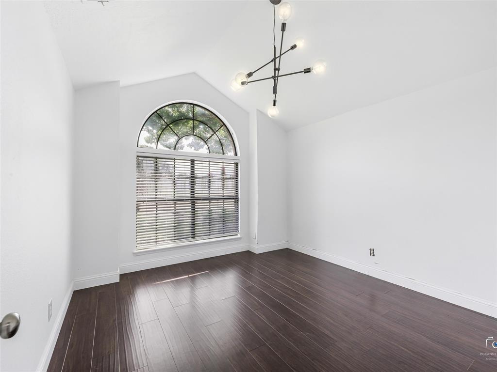 Bedroom three features a vaulted ceiling with an arch-top window, the same wood flooring, and a modern sputnik-style chandelier