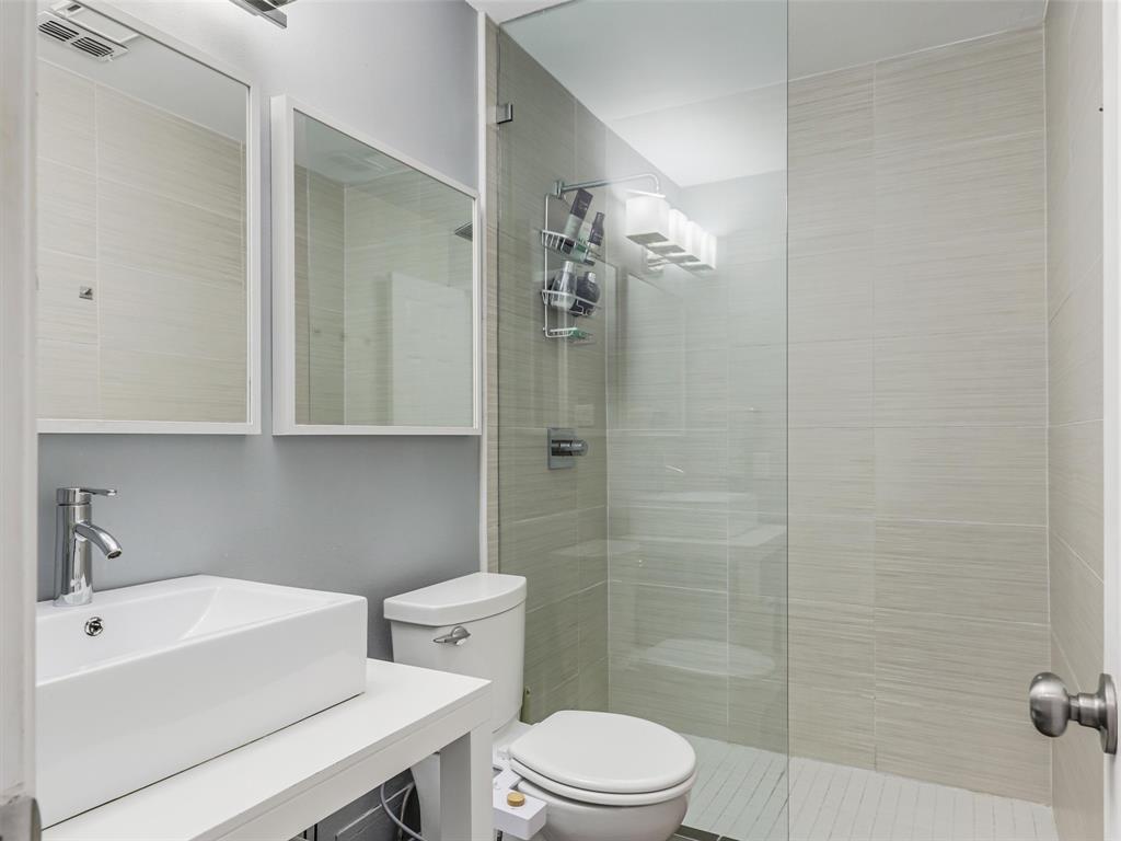 Bathroom two featuring a rectangular vessel sink, chrome faucet, and dual mirrors.