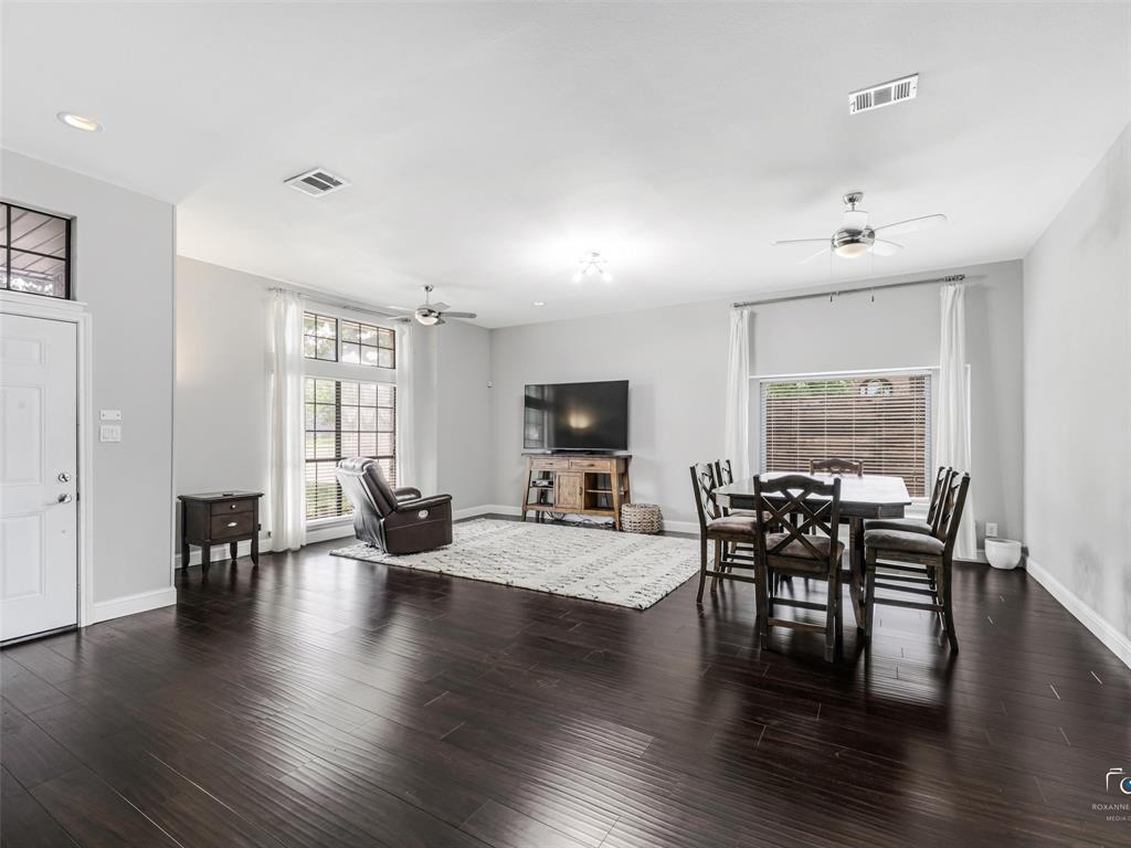 Open-concept living space features a living area and dining area with wood flooring, light gray walls, recessed lighting, two multiple ceiling fans and large windows providing ample natural light. Open-concept living space features a living area and dining area with wood flooring, light gray walls, recessed lighting, two multiple ceiling fans and large windows providing ample natural light.