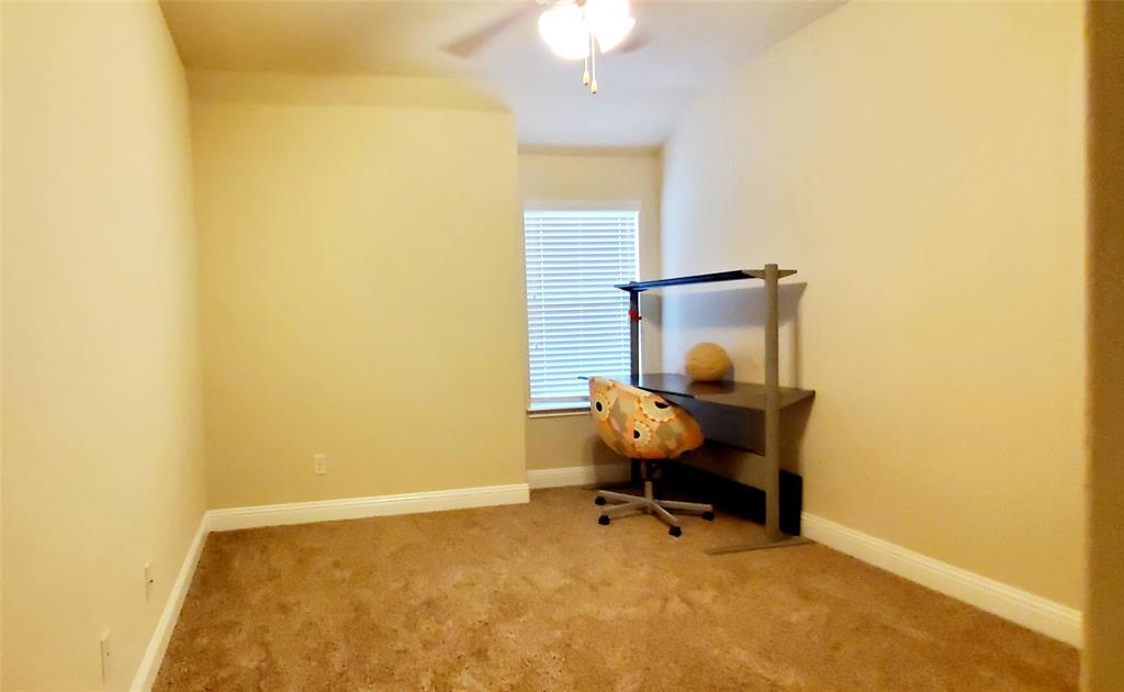 Carpeted room featuring a ceiling fan, window with blinds, and light-toned walls
