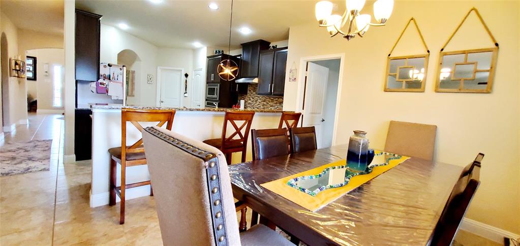 Dining area featuring a chandelier, a dark wood-finish table, and a neutral-toned upholstered chair