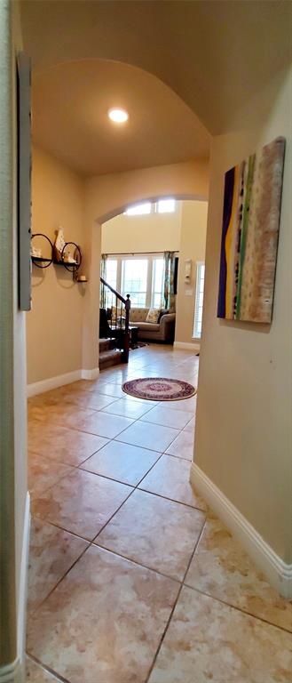Entryway featuring large format square tile flooring and arched doorways