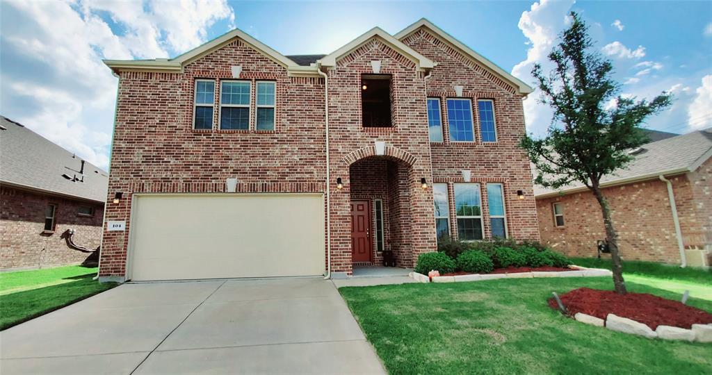 Brick exterior residence featuring an arched entry, two-story facade, and an attached garage