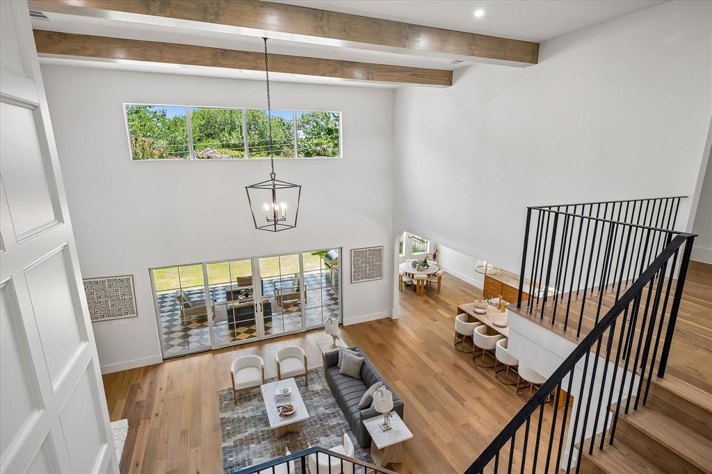 Living room overhead, stone fireplace, exposed beams, patio access
