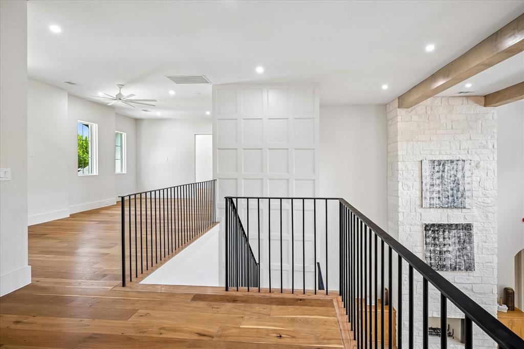 Second floor landing, iron railing overlook, board and batten accent wall, hardwood floors