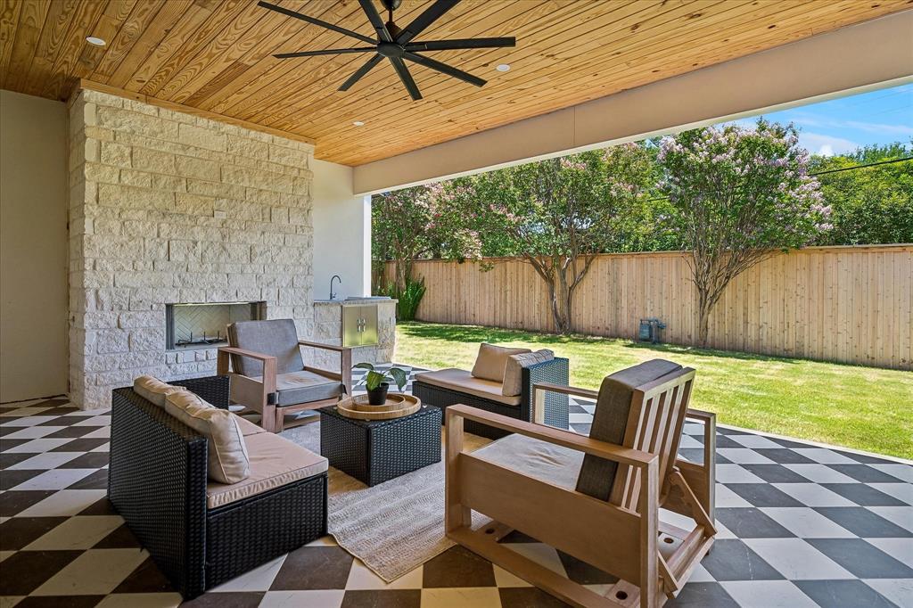 427 SF covered patio, stone fireplace, tongue and groove wood ceiling, ceiling fan, outdoor kitchen