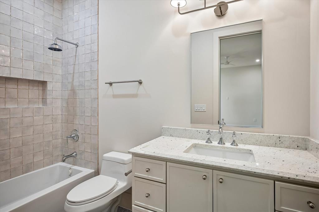 Bath, tub/shower combo, white glazed tile surround, stone countertop, single vanity