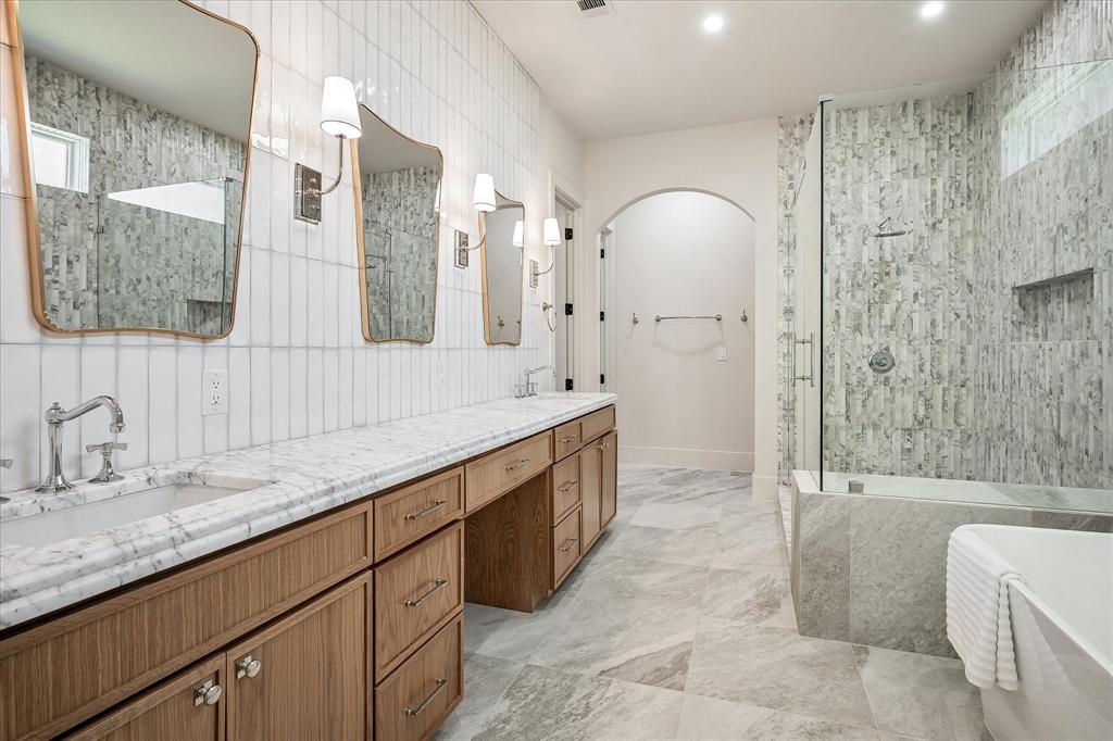 Primary bath, dual vanity, White Arabescato honed stone countertop, arched closet entry