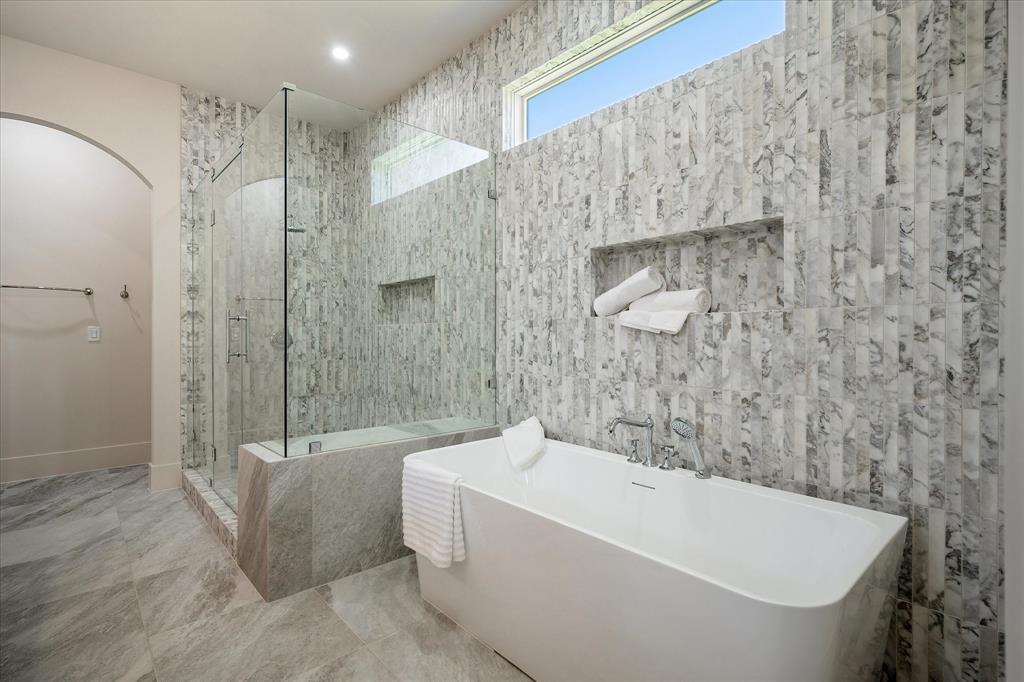 Primary bath, freestanding soaking tub, Calacatta Giallo tile surround, shower niche, clerestory window