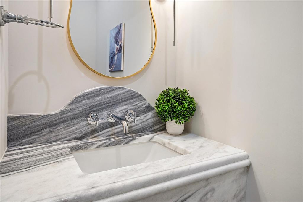 Powder, Shadow Storm honed stone countertop, wall-mount faucet, designer mirror