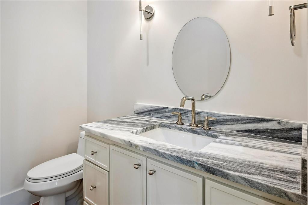 Powder, Shadow Storm stone countertop, round mirror, sconce lighting
