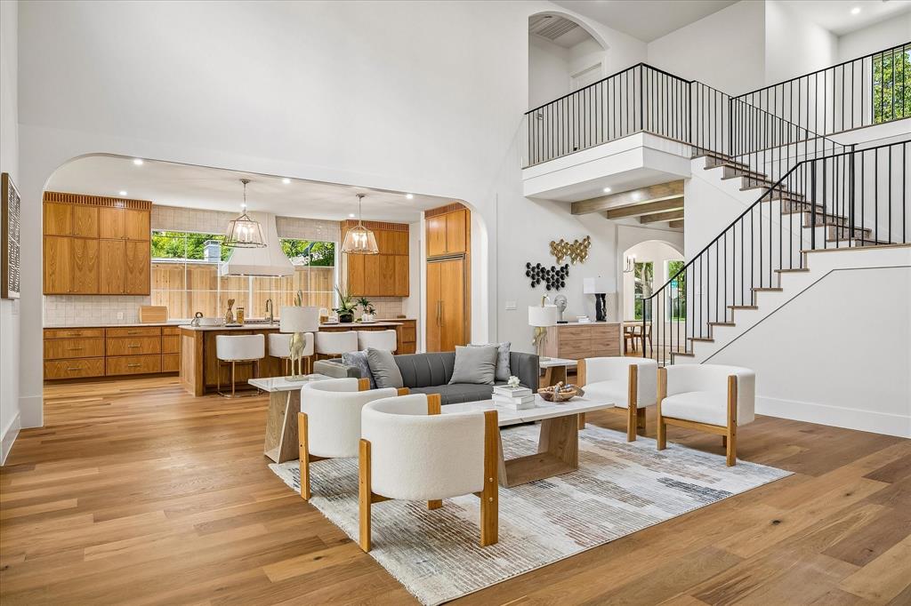 Open living and kitchen, arched transition, custom oak cabinetry, iron stair railing