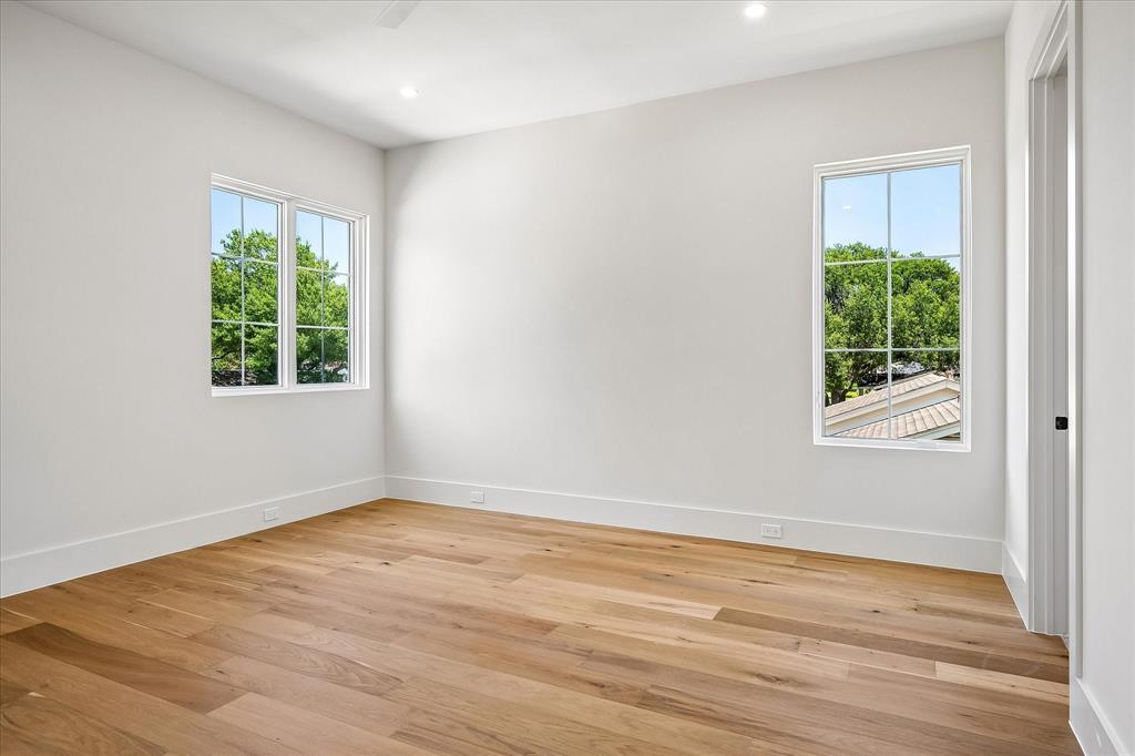 Secondary bedroom, hardwood floors, multi-window views, ceiling fan
