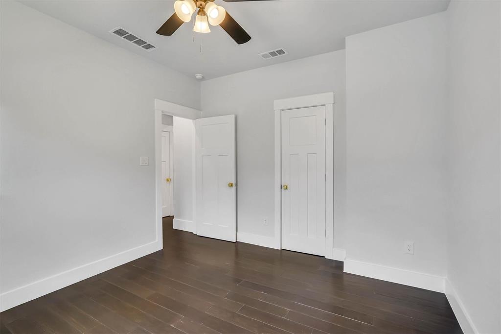 Interior room featuring dark wood-finish flooring, white baseboards, and light gray walls