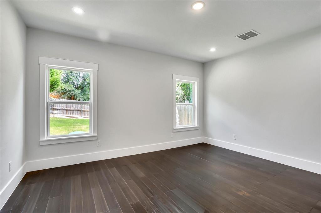 Room featuring dark wood-finish flooring, light gray wall paint, and white trim