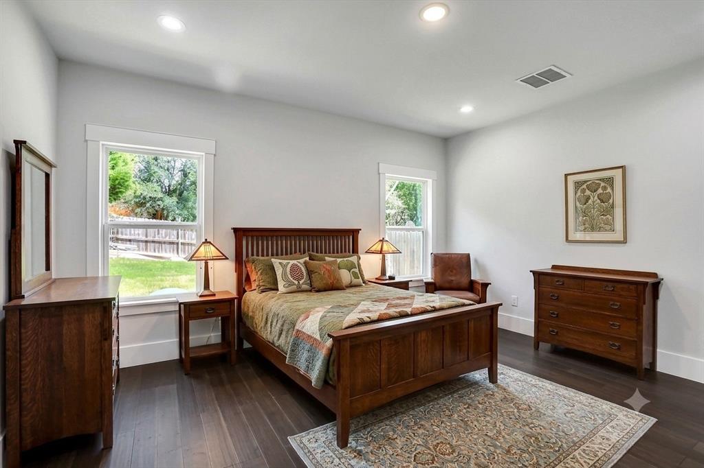 Spacious room featuring wood-finish flooring, recessed lighting, and two large windows with white trim