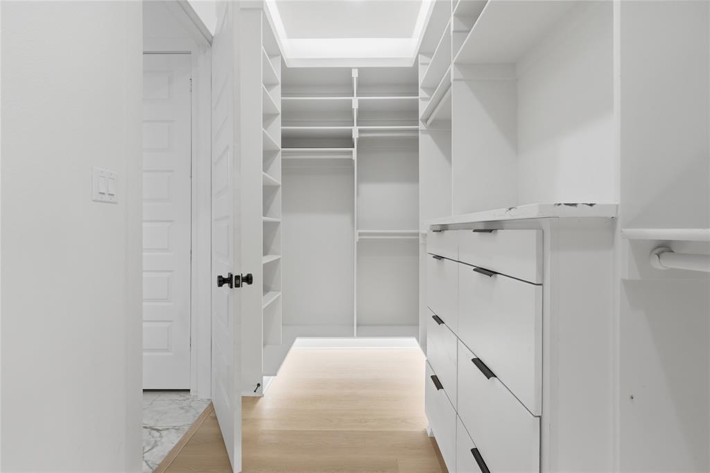 Custom closet organization system featuring white cabinetry and shelving