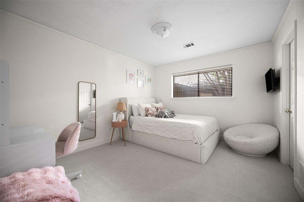 Light-filled bedroom featuring plush carpeting, a large window with blinds, and white wall finishes
