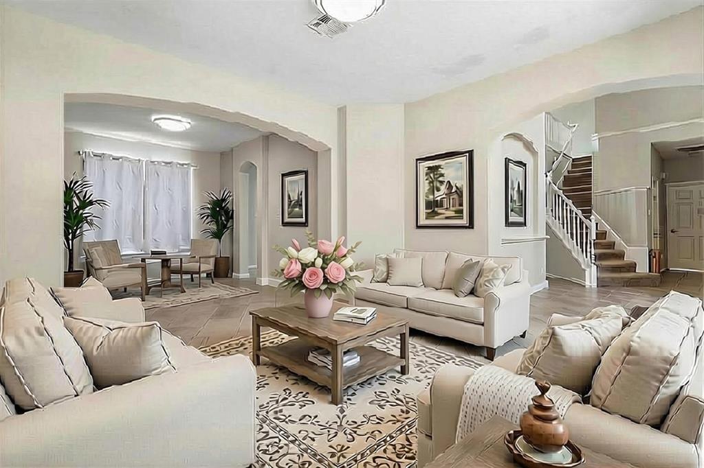 Open-concept living space featuring light-toned walls, arched doorways, and wood-finish flooring