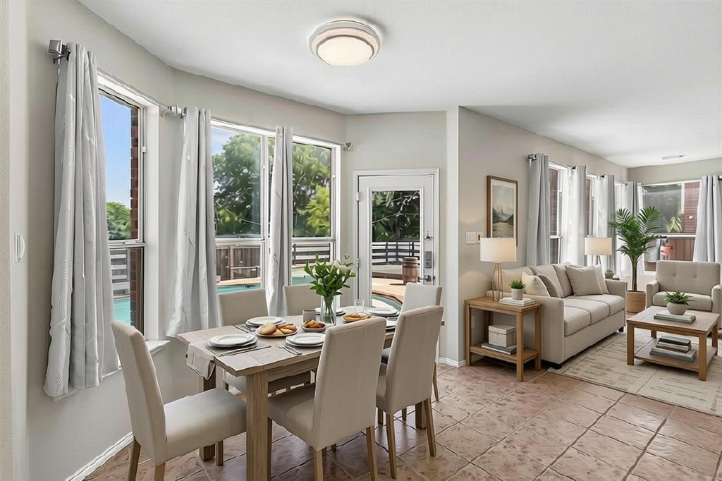 Open-concept dining and living areas bathed in natural light through multiple glass doors and windows with transom details