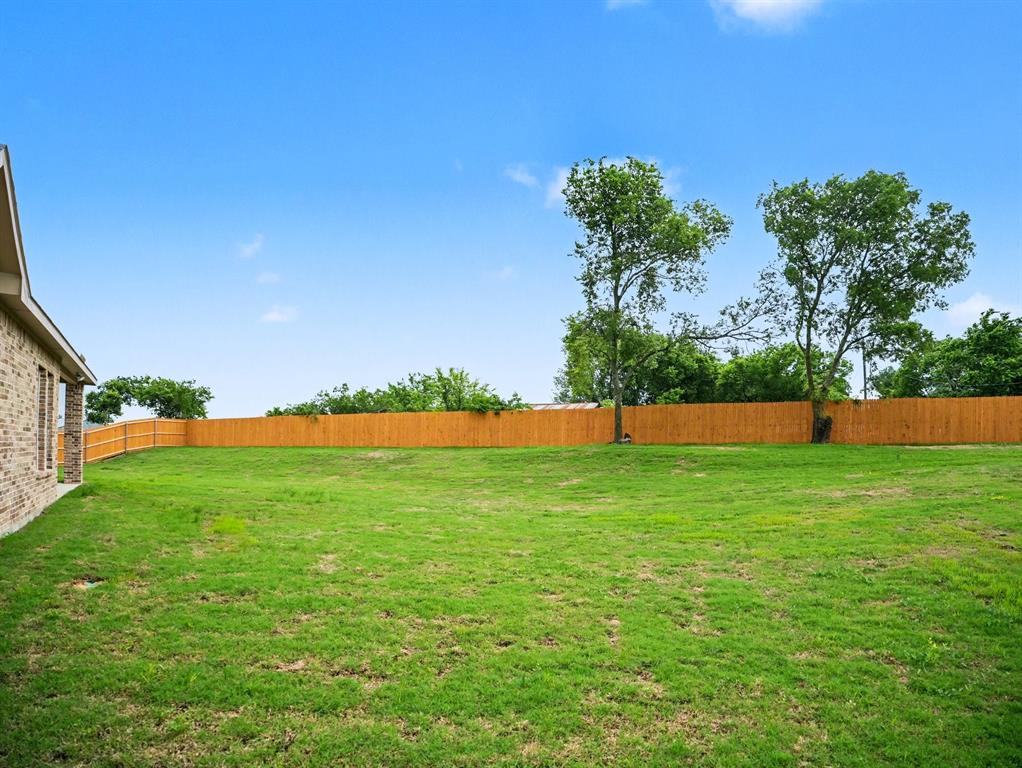 Expansive lawn area featuring a newly installed privacy fence