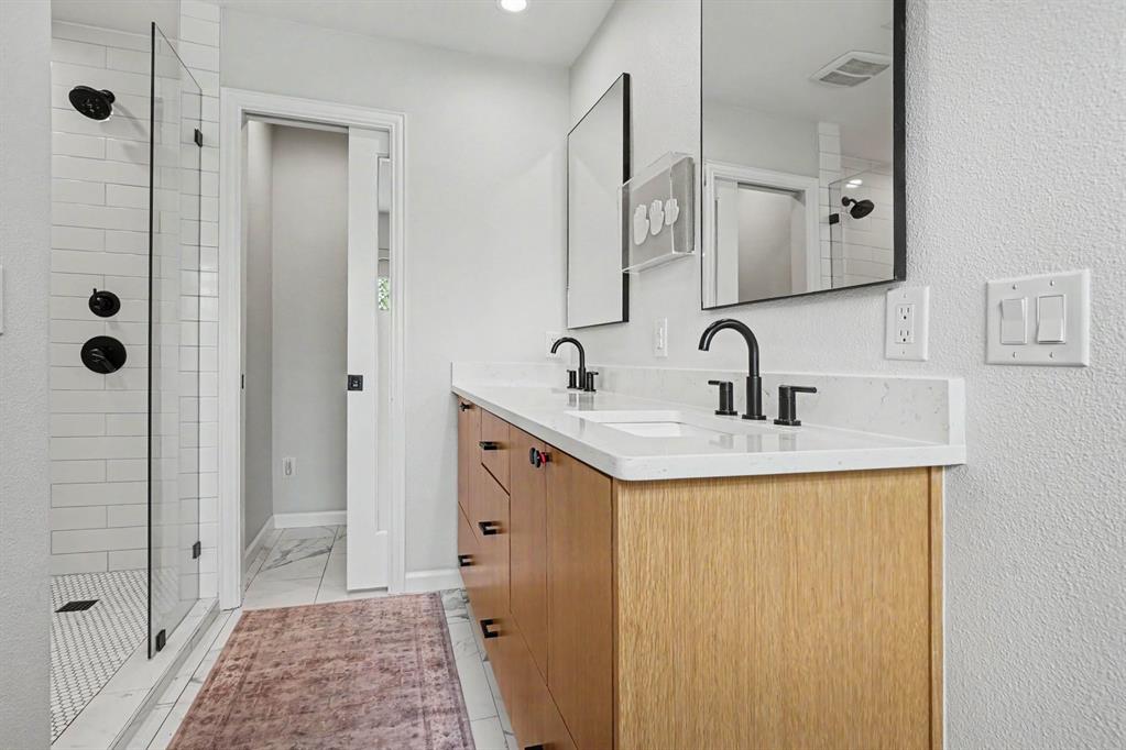 Newly remodeled primary bath with shower and tub area. Updated cabinets, counters, mirrors and hardware.