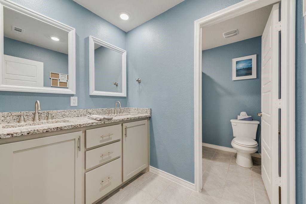 Double sinks and granite counters - high-end upgrade,  Framed mirrors and recessed lighting.
