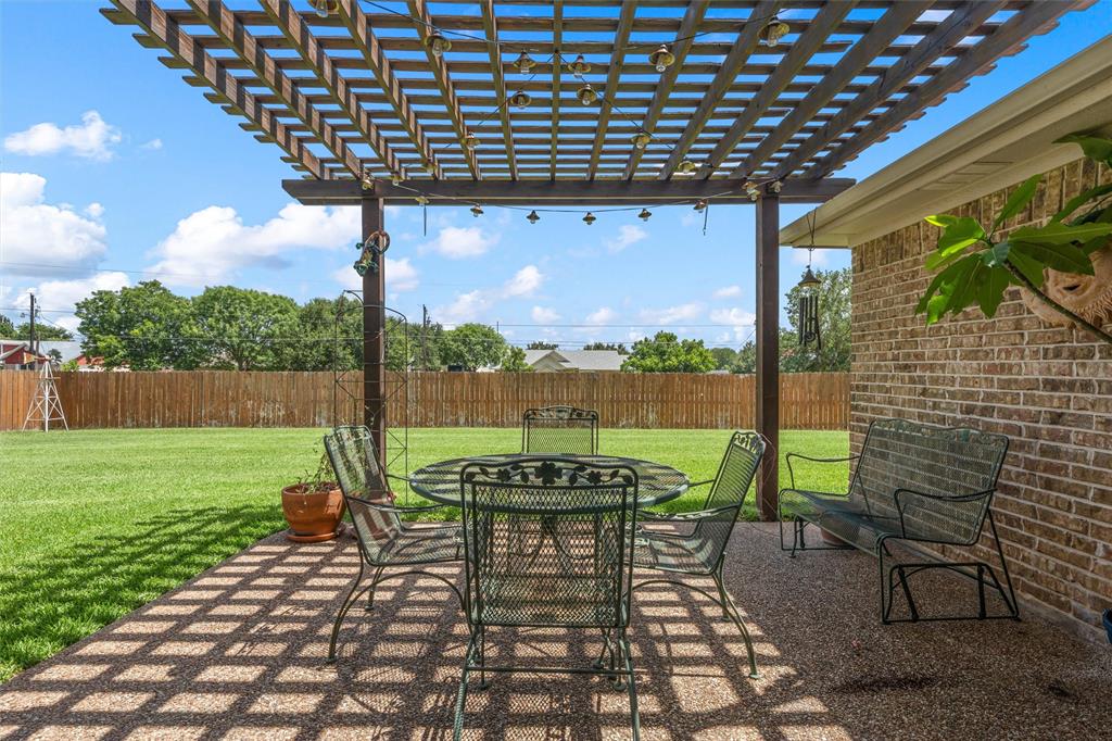 Expansive backyard featuring a wood pergola and a gravel patio Expansive backyard featuring a wood pergola and a gravel patio