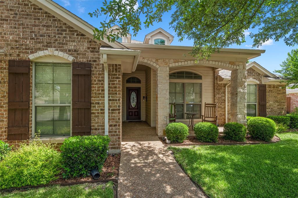 Brick and stone exterior featuring a covered porch with stone columns Brick and stone exterior featuring a covered porch with stone columns