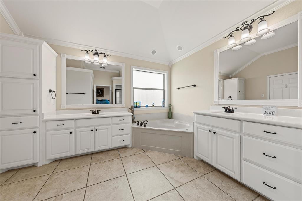 Bathroom featuring twin vanities with white cabinetry, white countertops, and framed mirrors Bathroom featuring twin vanities with white cabinetry, white countertops, and framed mirrors