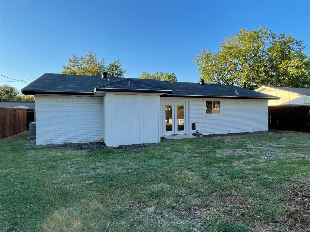 Back of property with french doors, cooling unit, and a yard