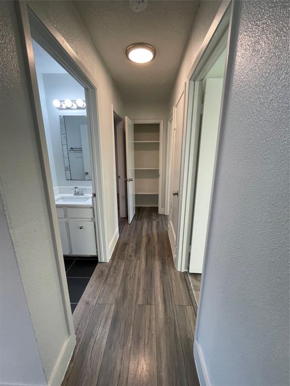 Hall with dark wood-type flooring and sink