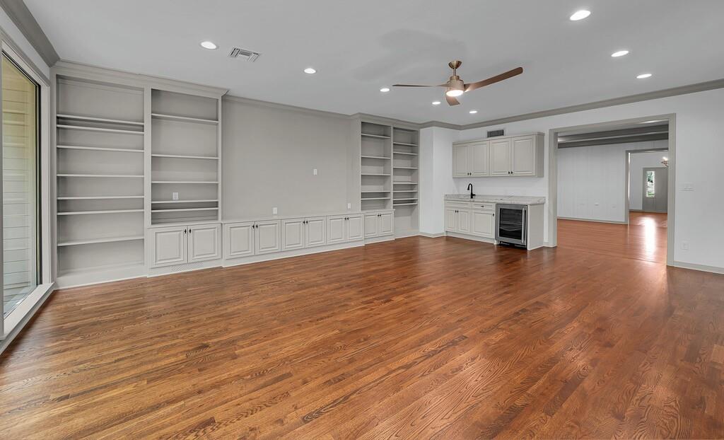 Spacious room featuring rich wood-finish flooring, recessed lighting, and a ceiling fan