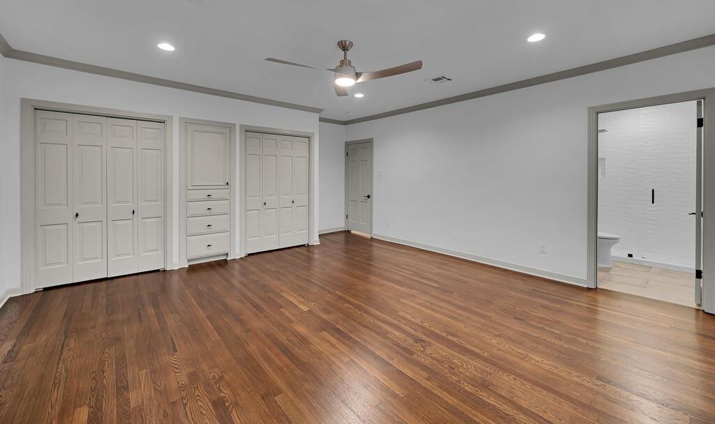 Spacious room featuring rich wood-finish flooring and light-toned walls