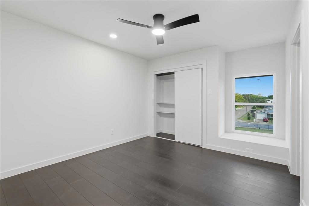 Spacious room featuring dark wood-finish flooring, a contemporary ceiling fan with integrated lighting, recessed lighting, and a white sliding door closet with built-in shelving