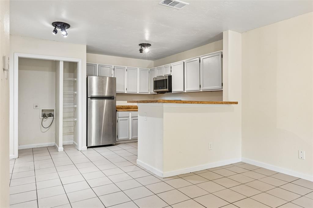 Kitchen area with tile flooring and track lighting