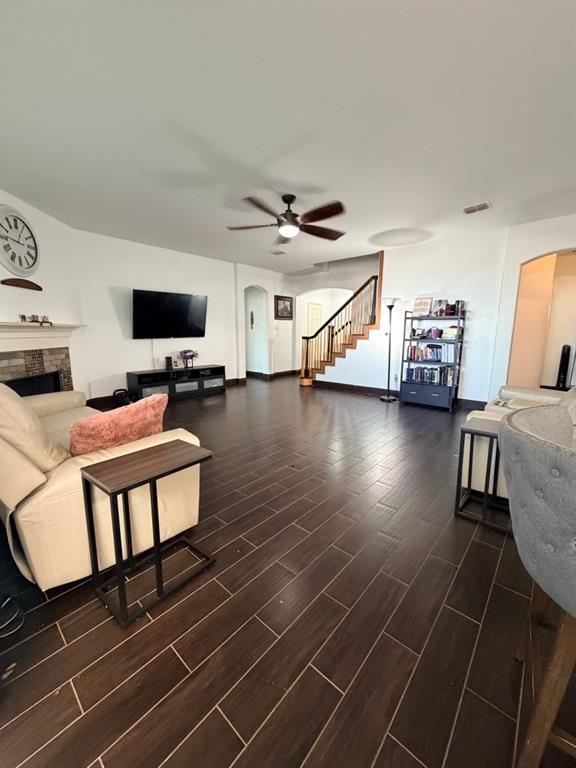 Spacious living area featuring plank-style tile flooring and a ceiling fan